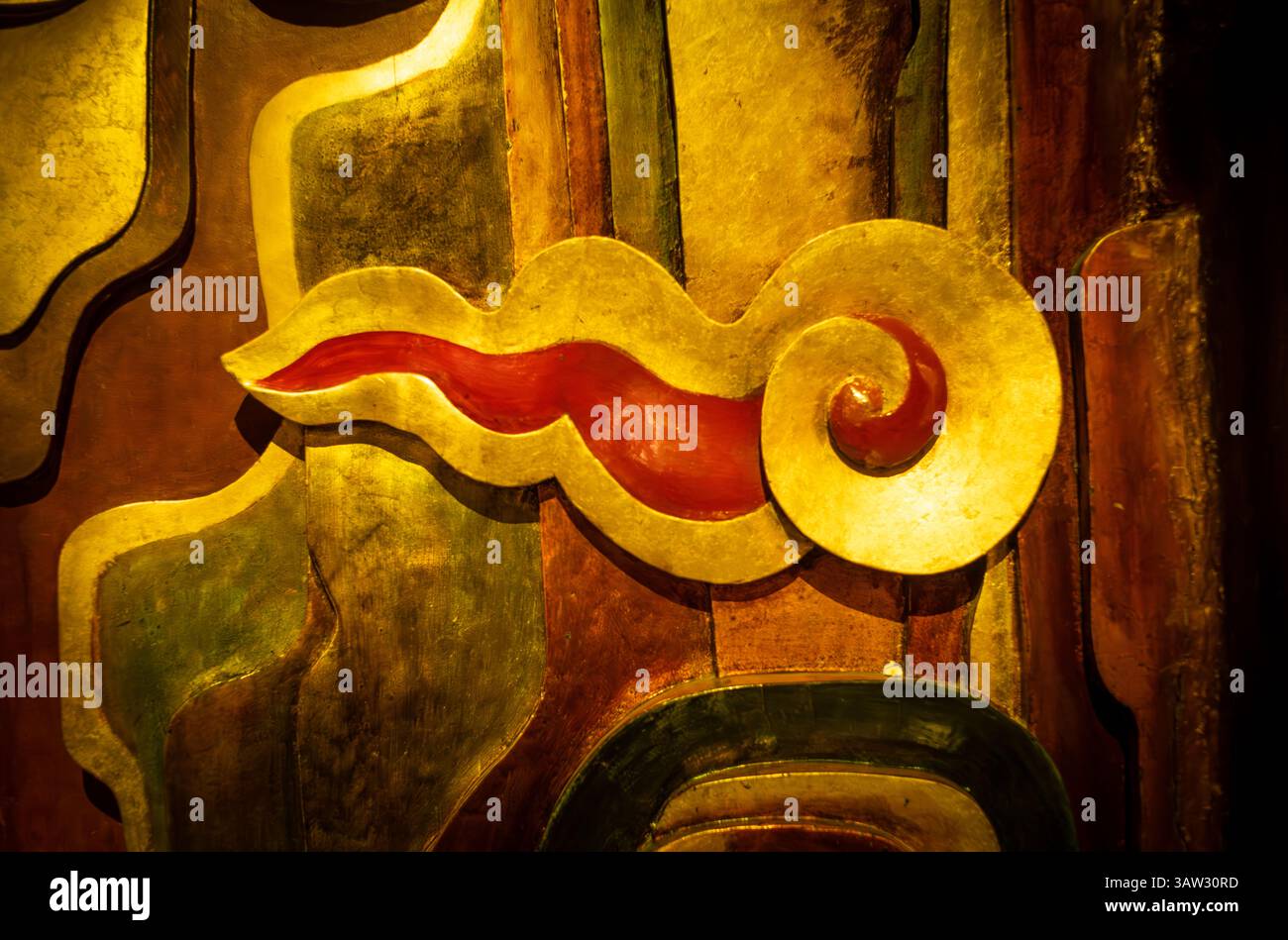 Panneau d'art laqué vietnamien avec un motif tourbillonnant or et rouge, exposé au Musée Ho Chi Minh à Hanoi, Vietnam. Banque D'Images