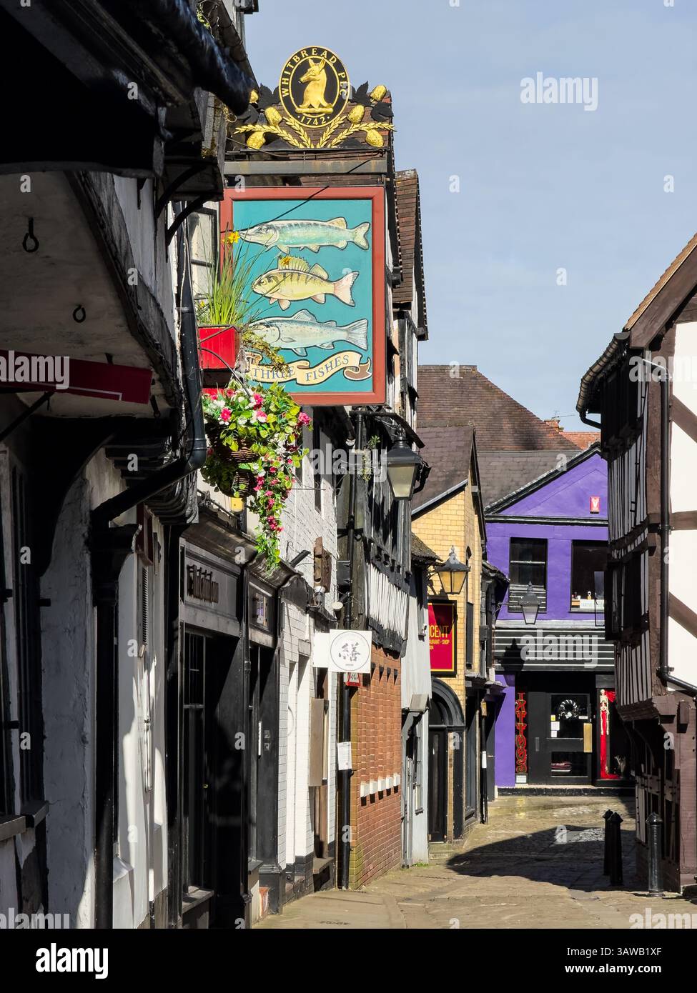 Shrewsbury, Angleterre, Royaume-Uni - 31 mars 2025 ; vue sur le paysage urbain le long de l'historique Fish Street dans le centre-ville de Shrewsbury avec la maison publique Three Fishes Banque D'Images