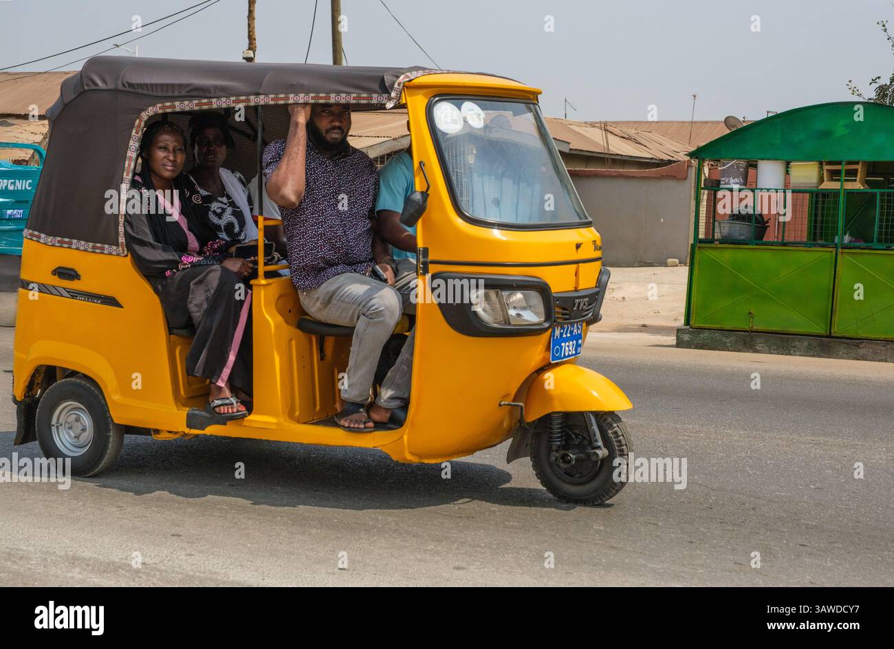 Ghana, Kumasi. Passagers dans le transport en taxi à trois roues. Banque D'Images
