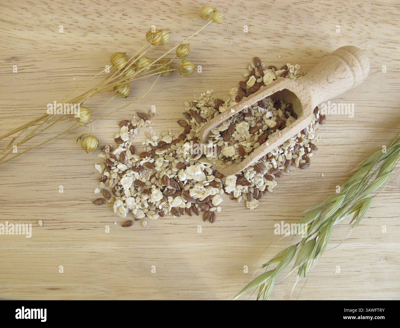 Mélange de graines avec flocons d'avoine, graines de lin et graines de sésame sur une planche de bois Banque D'Images