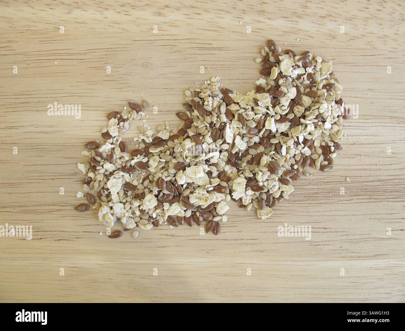 Mélange de graines avec flocons d'avoine, graines de lin et graines de sésame sur une planche de bois Banque D'Images