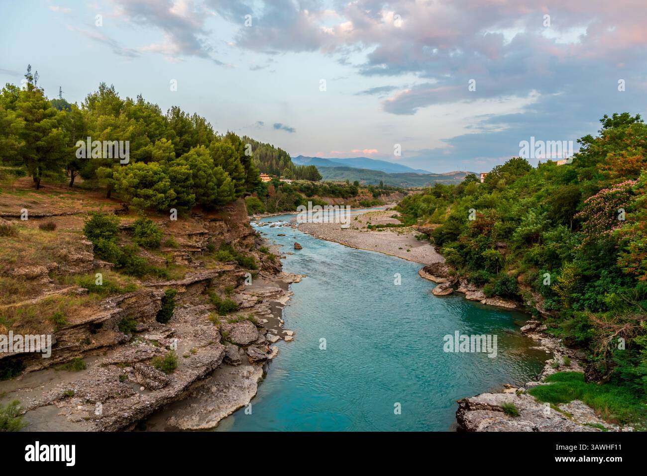 La rivière Vjosa près de Permet dans le sud-ouest de l'Albanie coule avec des courants turquoise entre des rives rocheuses sous des collines ondulantes et un ciel d'été tranquille Banque D'Images