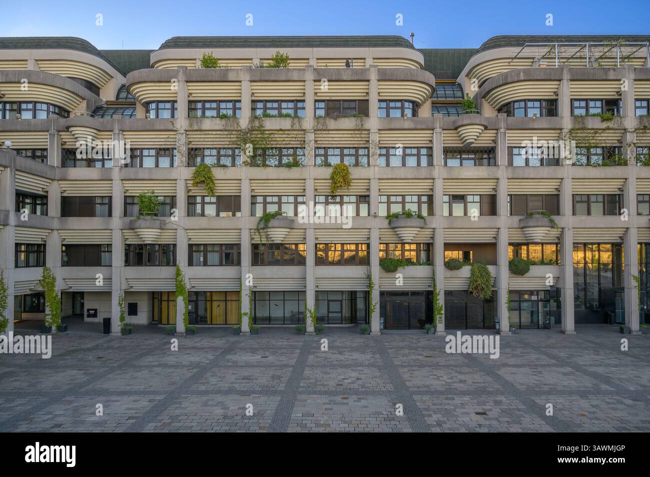 L'hôtel de ville de Linz, en Autriche, présente des éléments de design brutaliste saisissants et est orné de verdure. Les teintes douces du coucher de soleil reflètent son unique f Banque D'Images