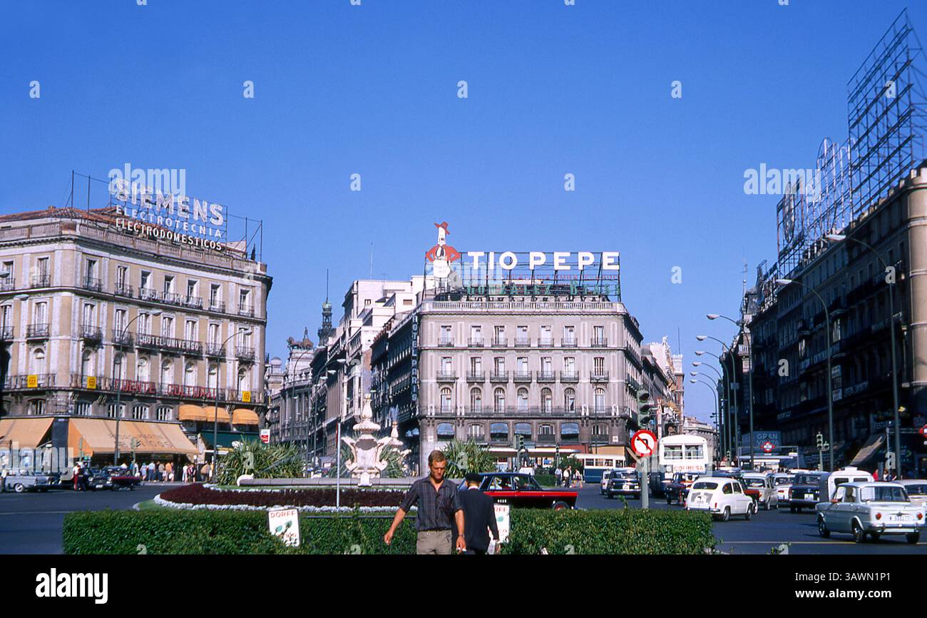 Place Puerta del sol à Madrid, Espagne, 1969, avec fontaine, trafic et publicités Siemens et Tio Pepe Banque D'Images