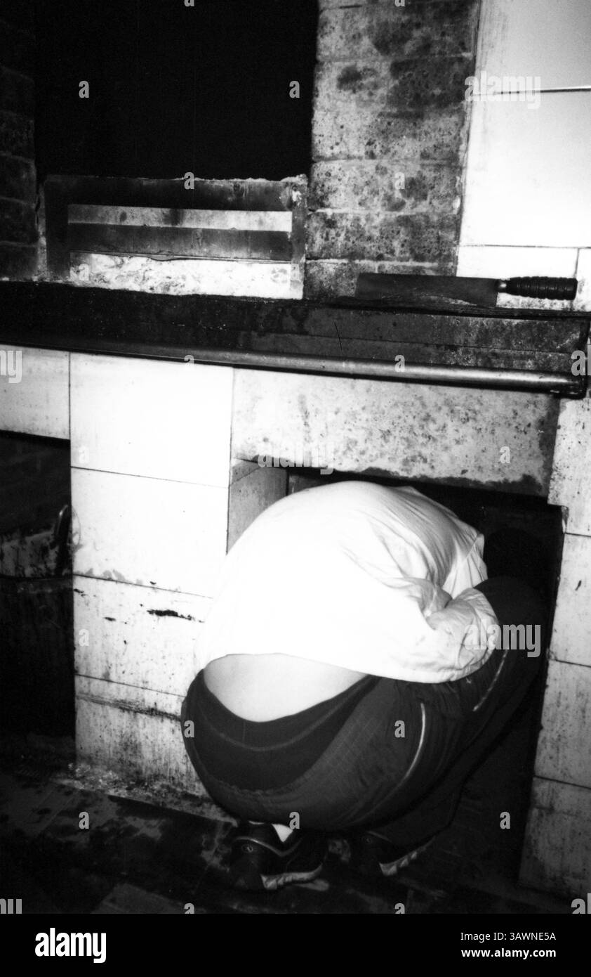 Ouvrier rampant dans le four à briques pour le nettoyage des cendres, années 2010, Tianjin, Chine Banque D'Images