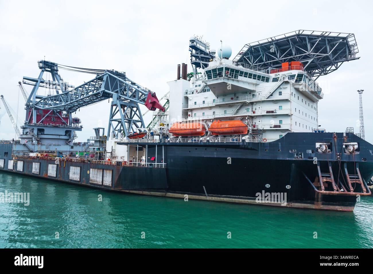 Un grand navire grue flottante offshore avec une grue et un héliport est amarré dans le port maritime de Rotterdam. Banque D'Images