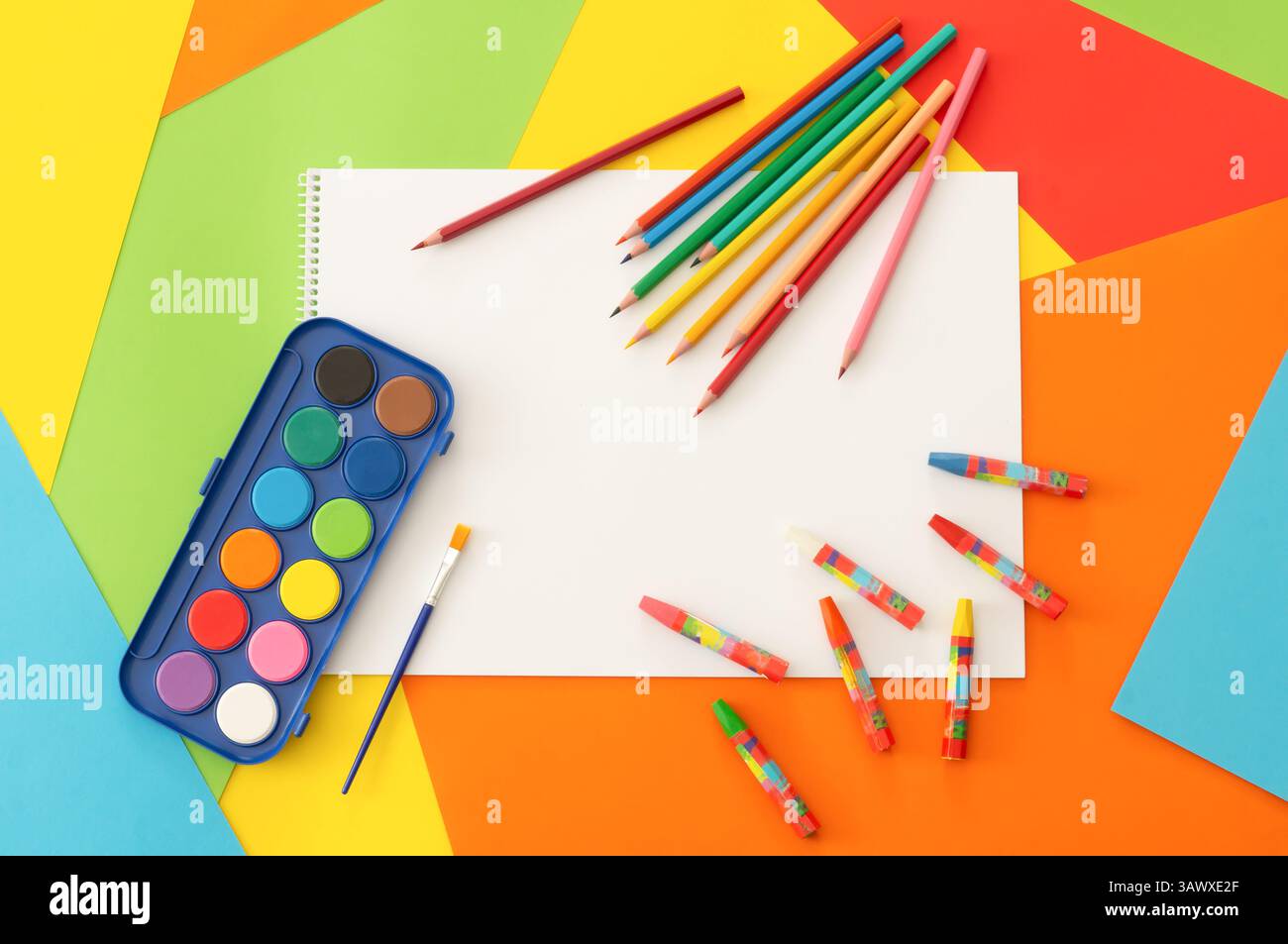 Crayons de couleur, crayons colorés, aquarelle et peinture pastel avec livre de dessin sur carton coloré, concept de peinture scolaire Banque D'Images