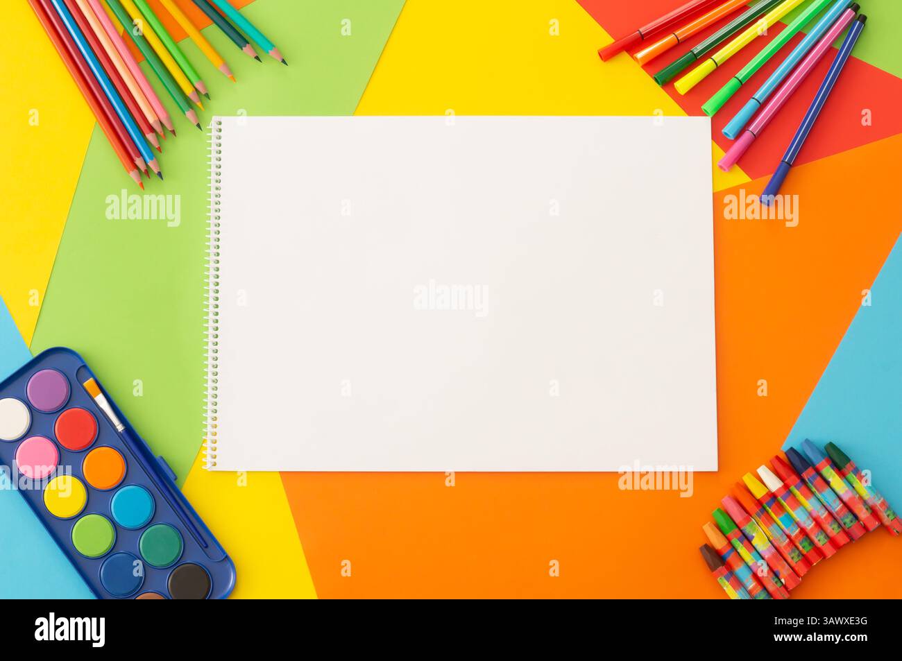 Crayons de couleur, crayons colorés, aquarelle et peinture pastel avec livre de dessin sur carton coloré, concept de peinture scolaire Banque D'Images