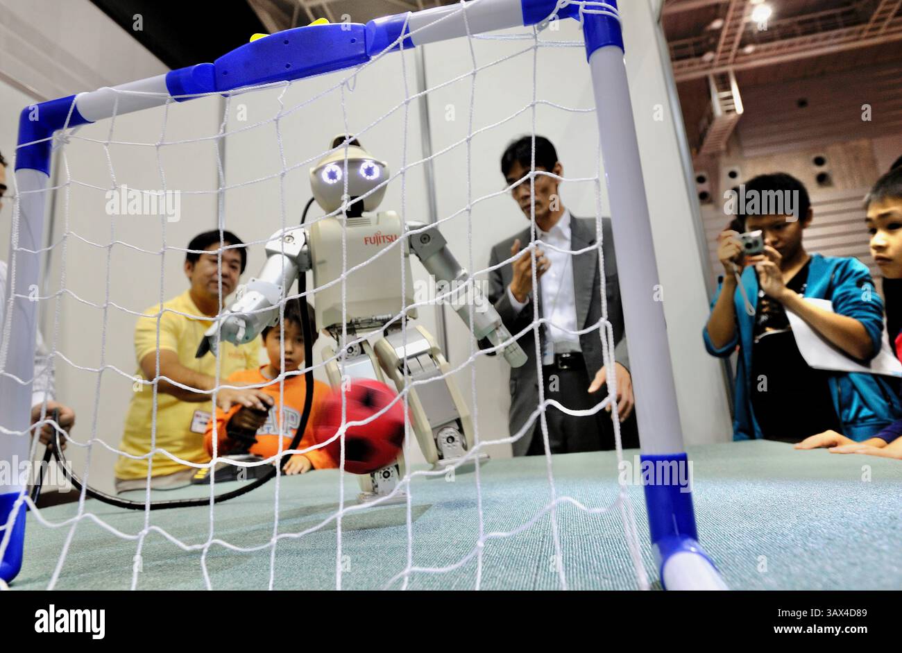 Le robot HOAP-3 de Fujitsu lance un ballon de football au Robo Japan 2008 à Yokohama, au Japon, le samedi 9 octobre 2008. Photographe : Robert Gilhooly Banque D'Images