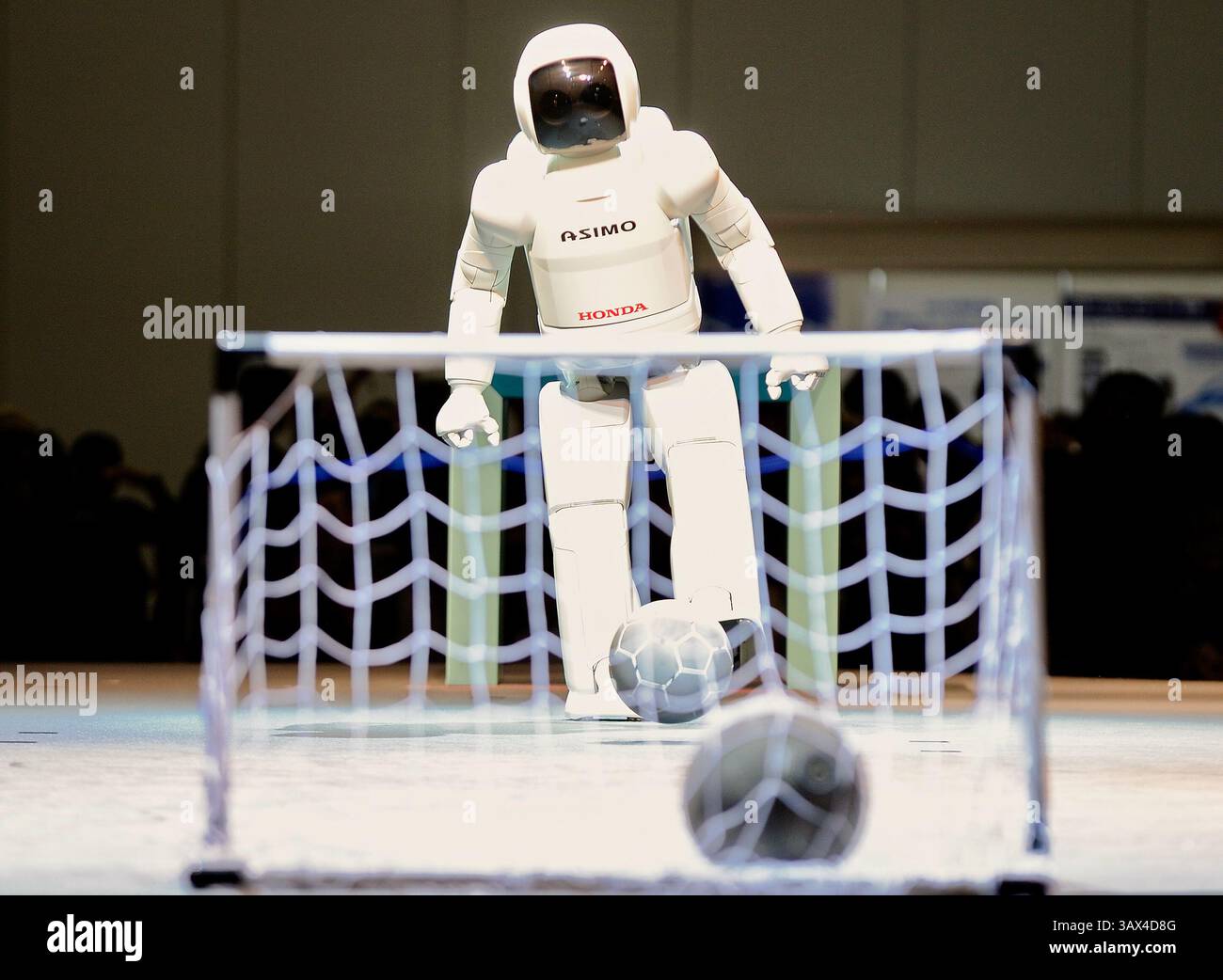 Le robot humanoïde Asimo de Honda tire un coup de pied sur un ballon de football lors d'une exposition au Robo Japan 2008 à Yokohama, au Japon, le samedi 9 octobre 2008. Photographe : Rob Banque D'Images