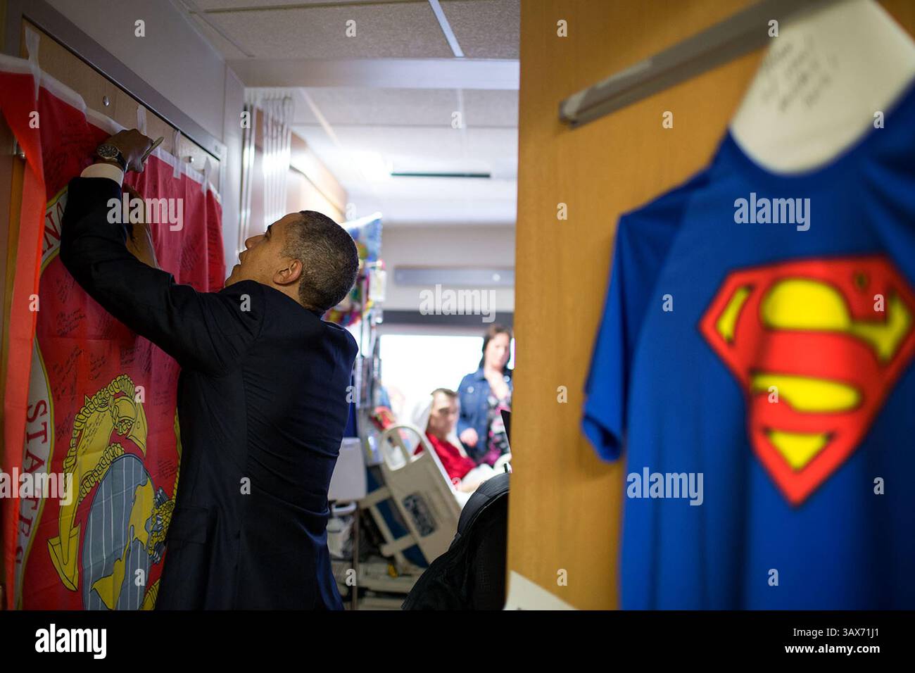 17 mars 2014 - Washington, DC, États-Unis d'Amérique - le président américain Barack Obama signe un drapeau du corps des Marines après avoir présenté un cœur violet au NMC Richard Whitney au Walter Reed National Military Medical Center le 17 mars 2014 à Bethesda, Maryland. Barack Hussein Obama II (né le 4 août 1961) est le 44e président des États-Unis. Il est le premier Afro-américain à être élu et le premier président né en dehors des États-Unis contigus. Né à Honolulu, Hawaï, Obama est diplômé de l'Université Columbia et de la Harvard Law School. Il a travaillé comme avocat des droits civils an Banque D'Images