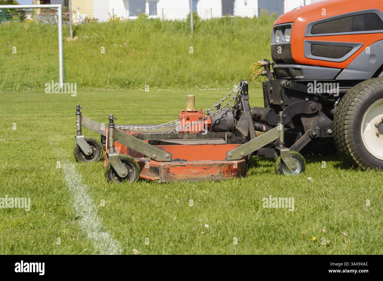 L'installation sportive est tondue avec un tracteur de pelouse - entretien de pelouse Banque D'Images