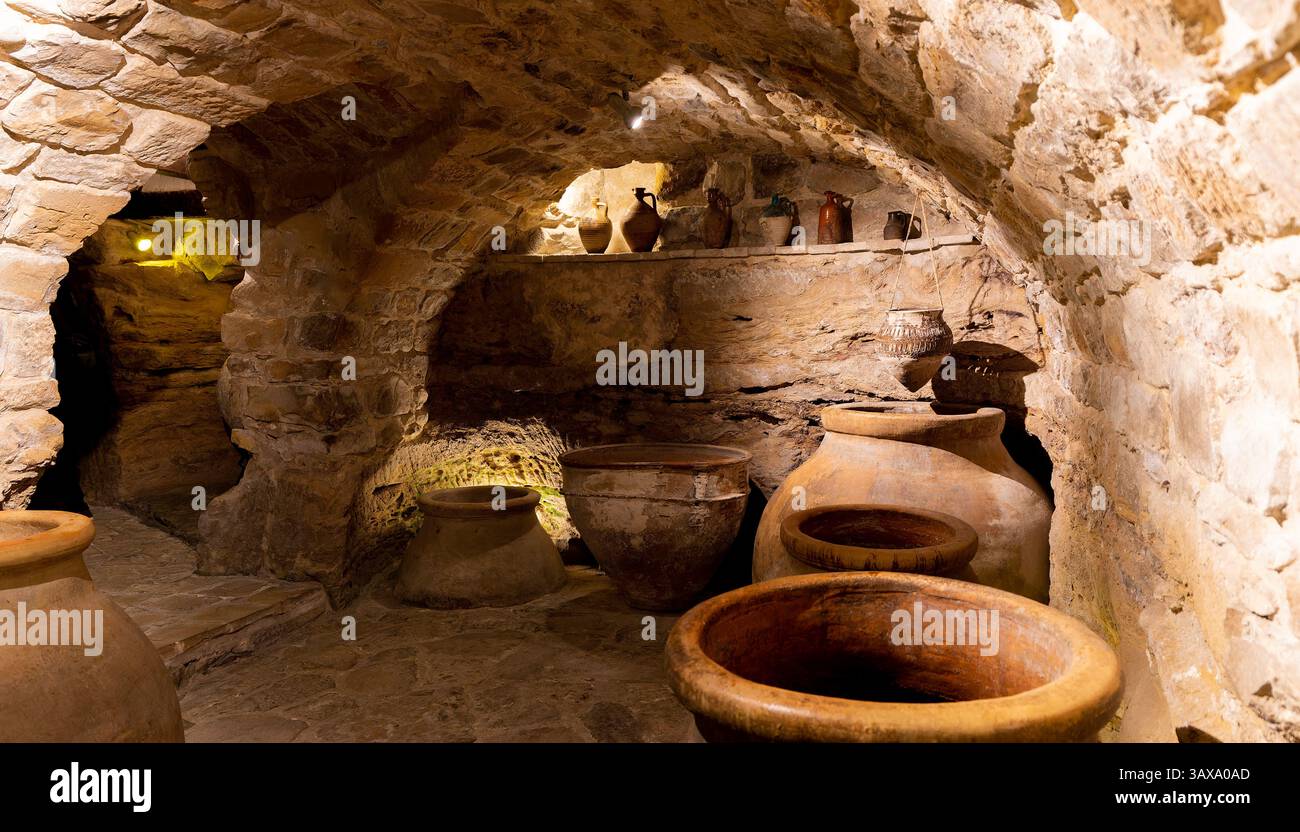 Une pièce avec beaucoup de vases et un plafond en pierre. Les vases sont de différentes tailles et formes, et ils sont disposés de manière à créer un sentiment de Banque D'Images