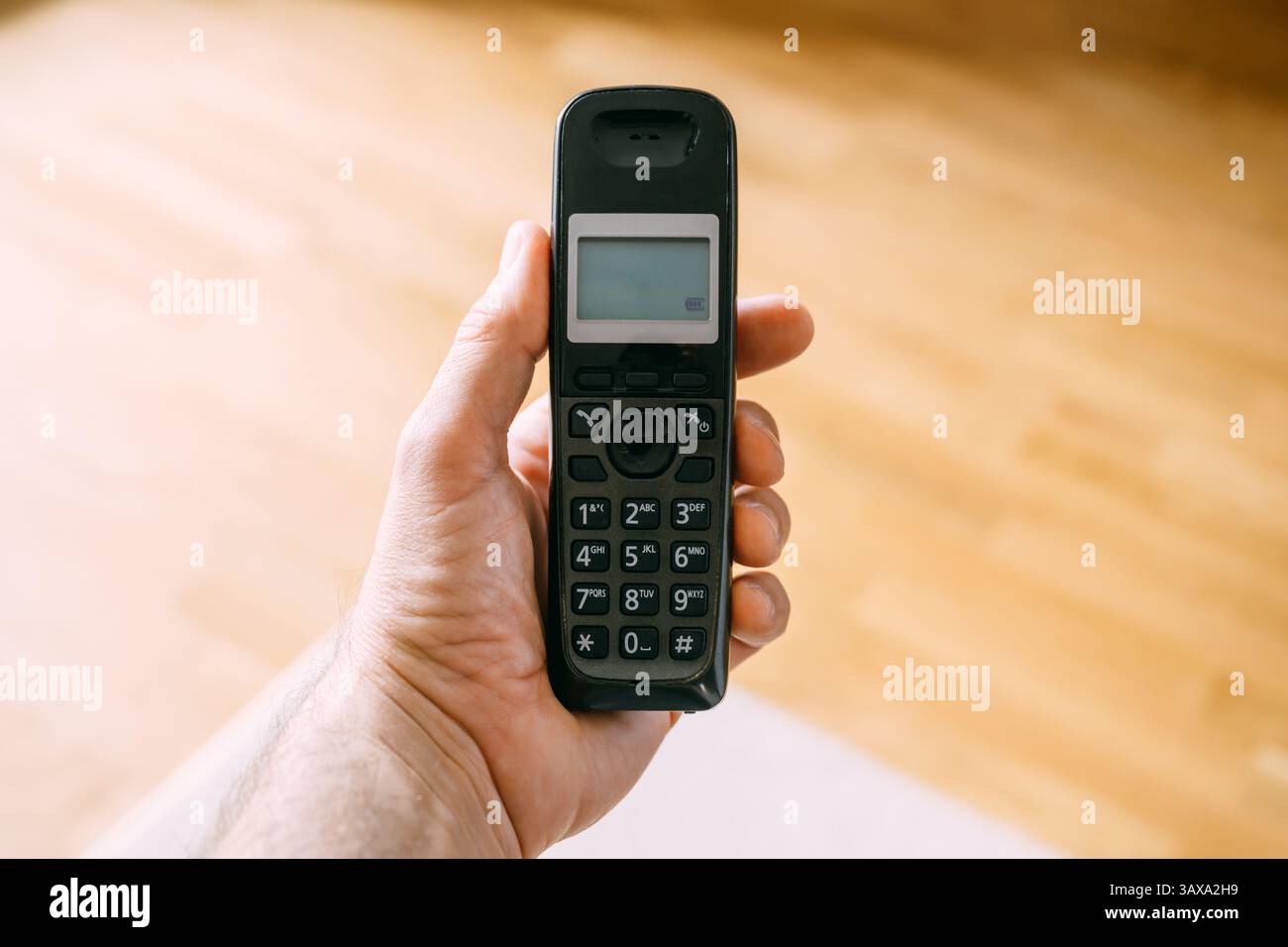 Main masculine avec téléphone fixe sans fil, mise au point sélective Banque D'Images