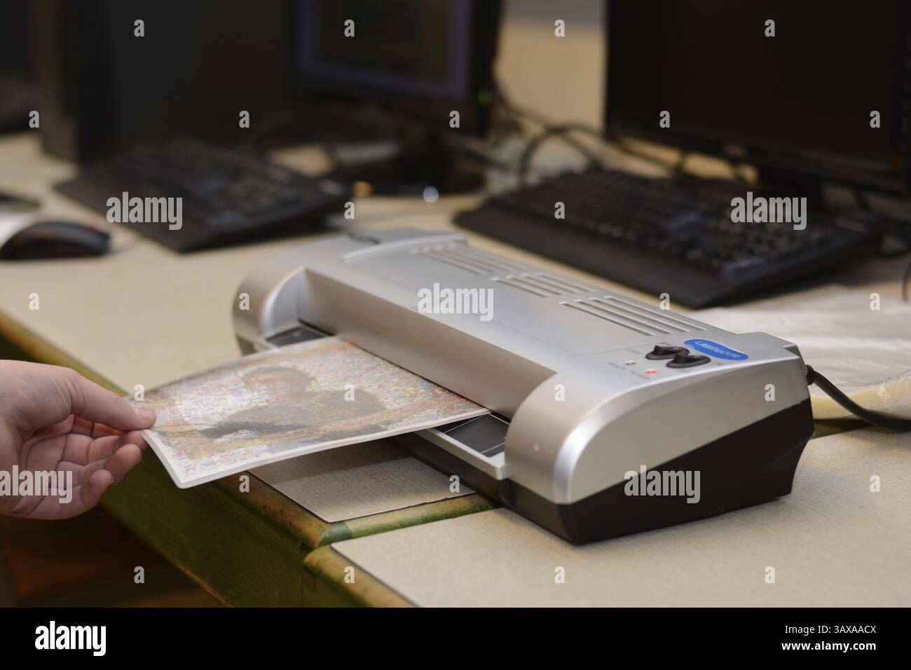 Personne plastifiant une image imprimée Banque D'Images