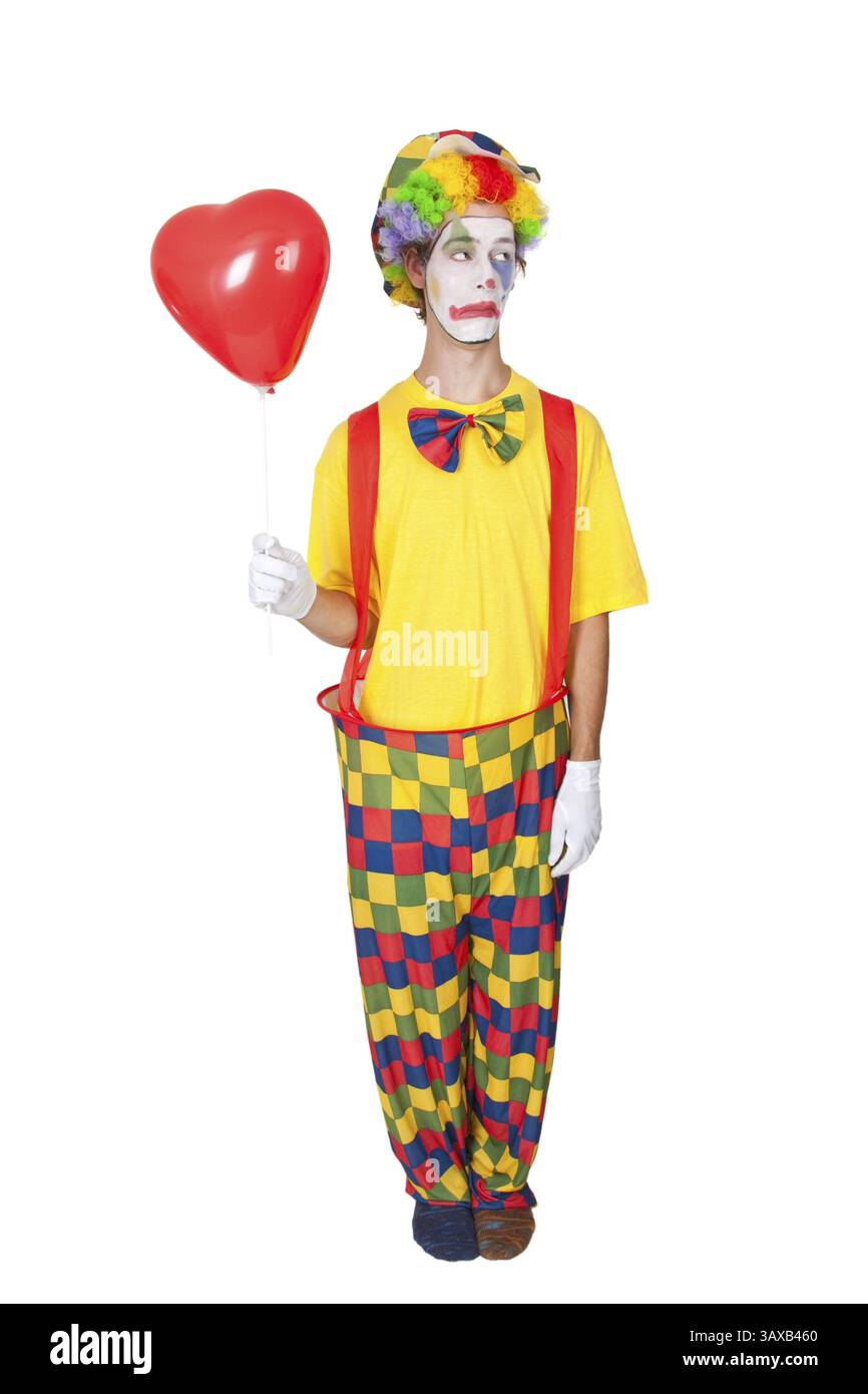 Jeune homme comme clown avec ballon rouge - isolé jeune homme comme clown avec ballon rouge - isolé Banque D'Images