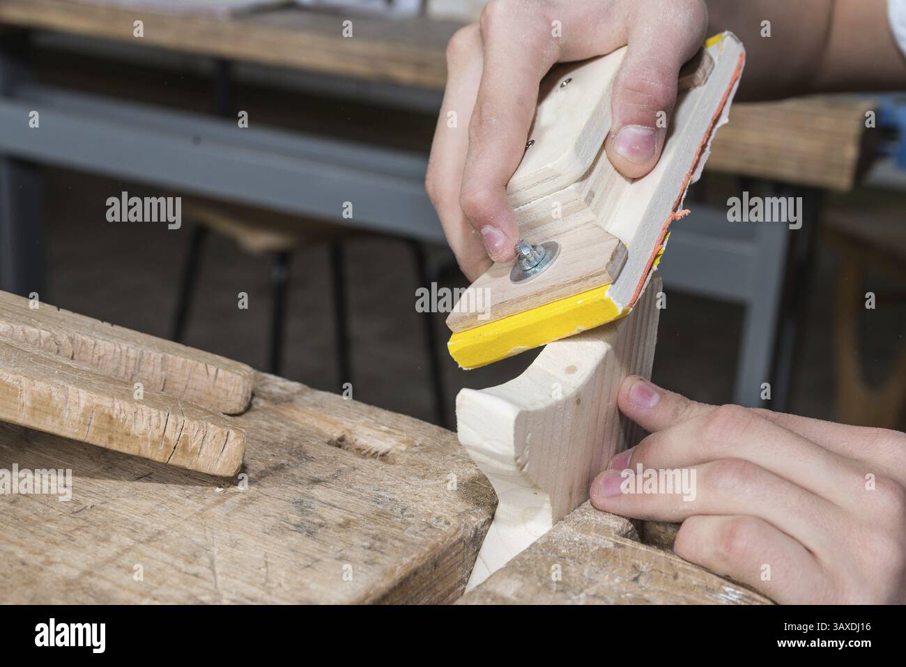 Ponçage fin avec du papier de verre sur un bloc de ponçage - atelier de menuiserie et menuiserie Banque D'Images
