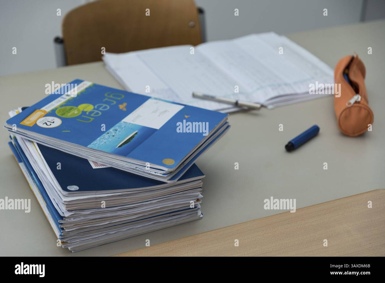 Pile de travaux scolaires sur le bureau du professeur pendant la correction Banque D'Images