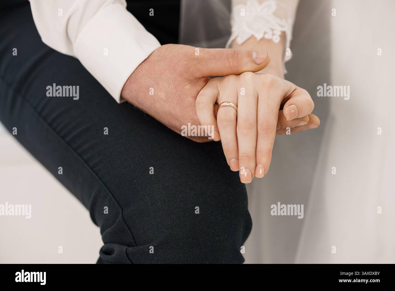 Moment de mariage intime : mains attachées avec des anneaux de mariage d'or symbolisant l'amour et l'engagement lors d'un jour spécial 182. Banque D'Images