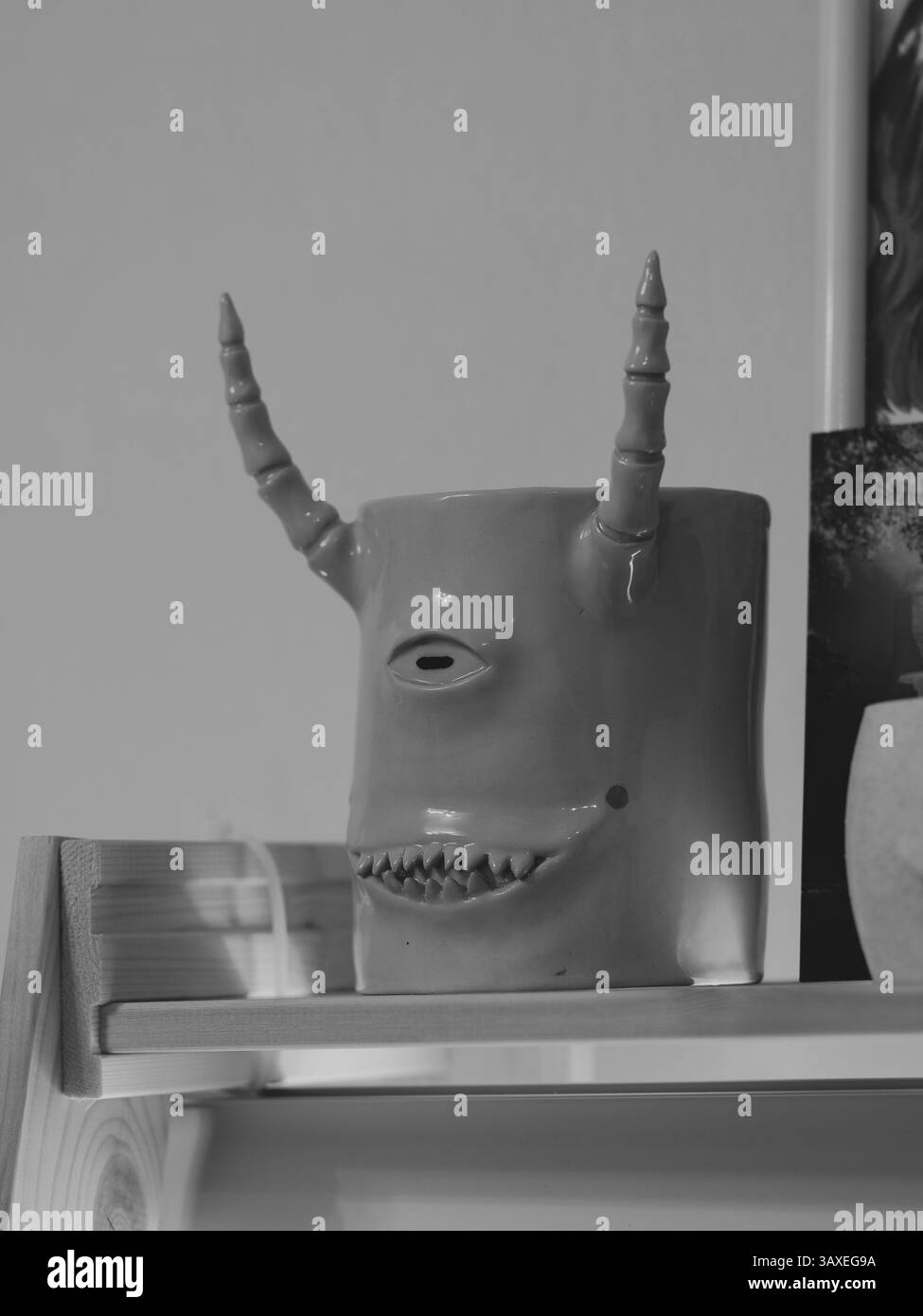 Un monstre surréaliste Peering mystérieusement de l'intérieur d'un réfrigérateur en noir et blanc Banque D'Images