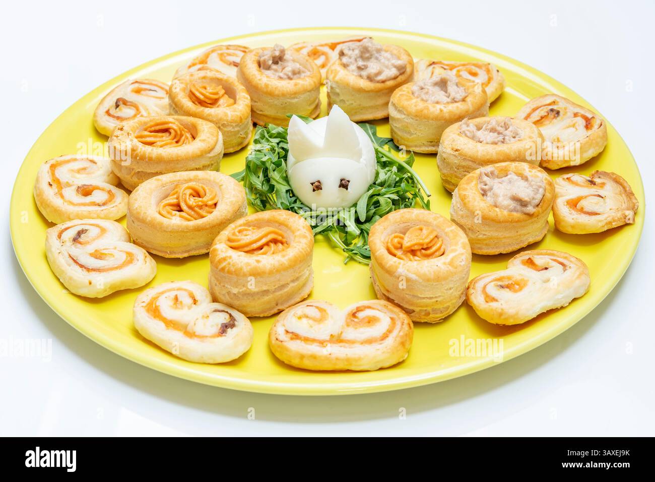 Un oeuf dur en forme de lapin, entouré d'une petite pâte feuilletée fourrée de saumon et de crème de thon Banque D'Images