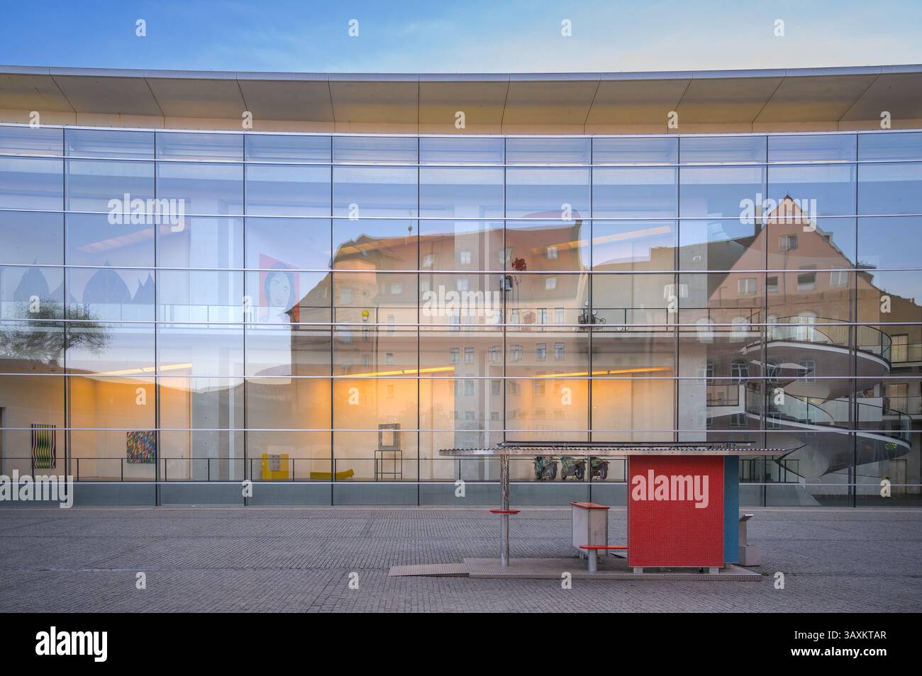 La façade en verre du Neues Museum présente un mélange de design contemporain et de bâtiments historiques à proximité, créant un contraste visuel saisissant Banque D'Images