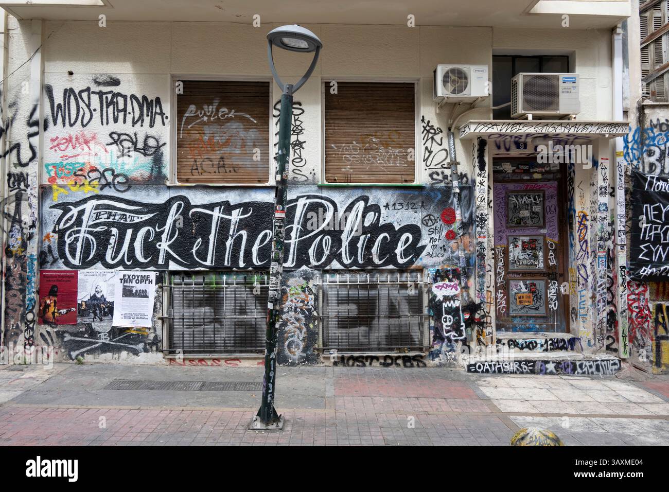 Graffiti anarchiste et anti-police sur la façade d'un squat dans le quartier d'Exarcheia à Athènes, Grèce. Banque D'Images