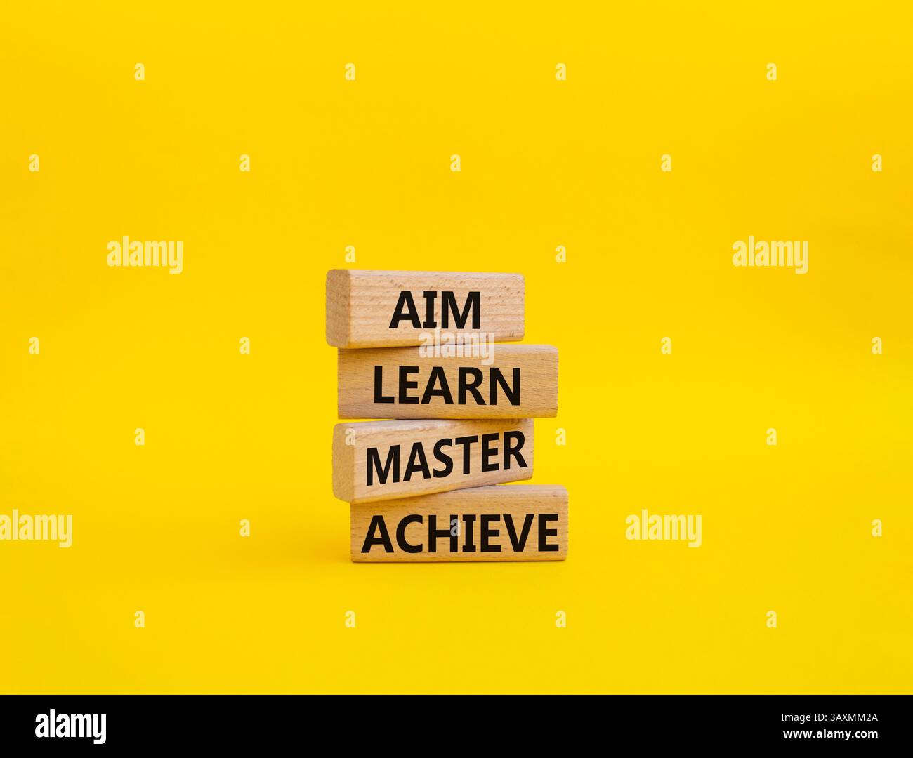 Symbole AIM apprendre Maître réaliser. Mot concept AIM apprendre Master Achieve sur des blocs de bois. Beau fond jaune. Business et AIM apprendre Master AC Banque D'Images