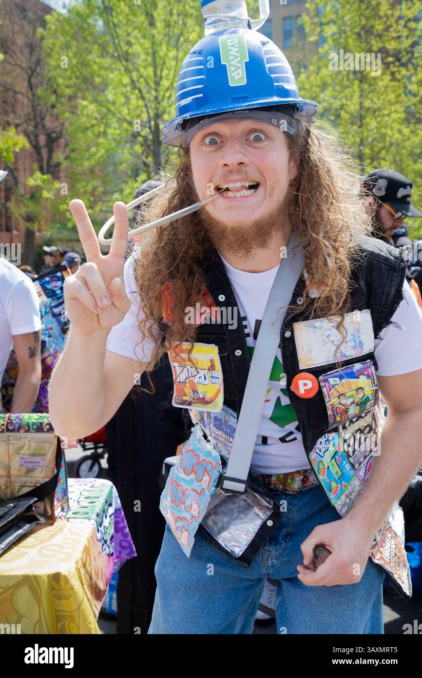 Au pot Smoke-in à Washington Square Park, un homme aux cheveux longs portant un casque avec un inhalateur de mauvaises herbes DynaVap. Il semble fumer de la marmite. Banque D'Images
