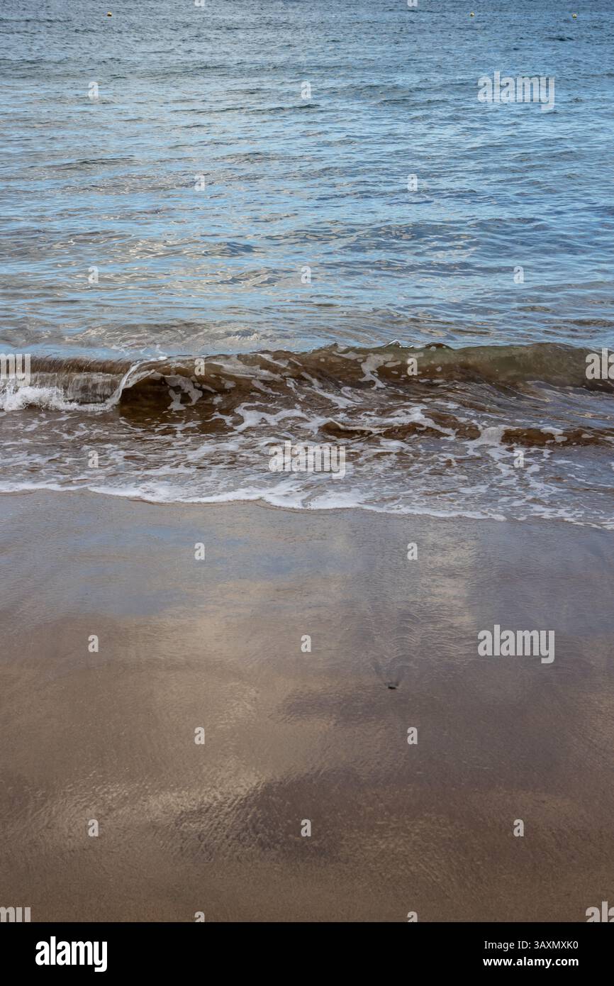 Plage de sable en début de soirée, lorsque le soleil est bas. Ligne de la marée et reflet du soleil, du ciel et des nuages. Playa del Cabron, Las Palmas, G. Banque D'Images