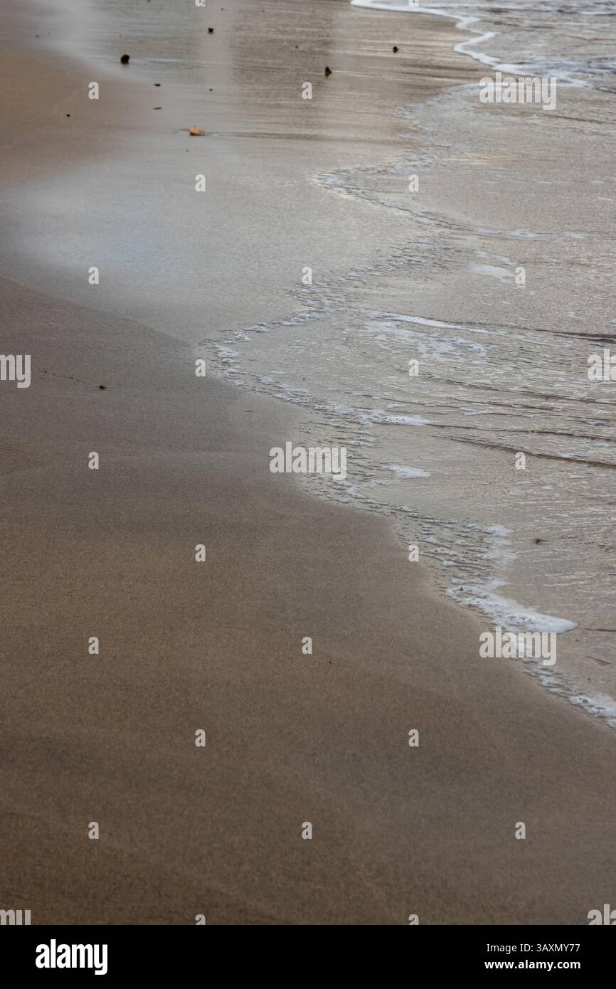 Plage de sable en début de soirée, lorsque le soleil est bas. Ligne de la marée et reflet du soleil, du ciel et des nuages. Playa del Cabron, Las Palmas, G. Banque D'Images