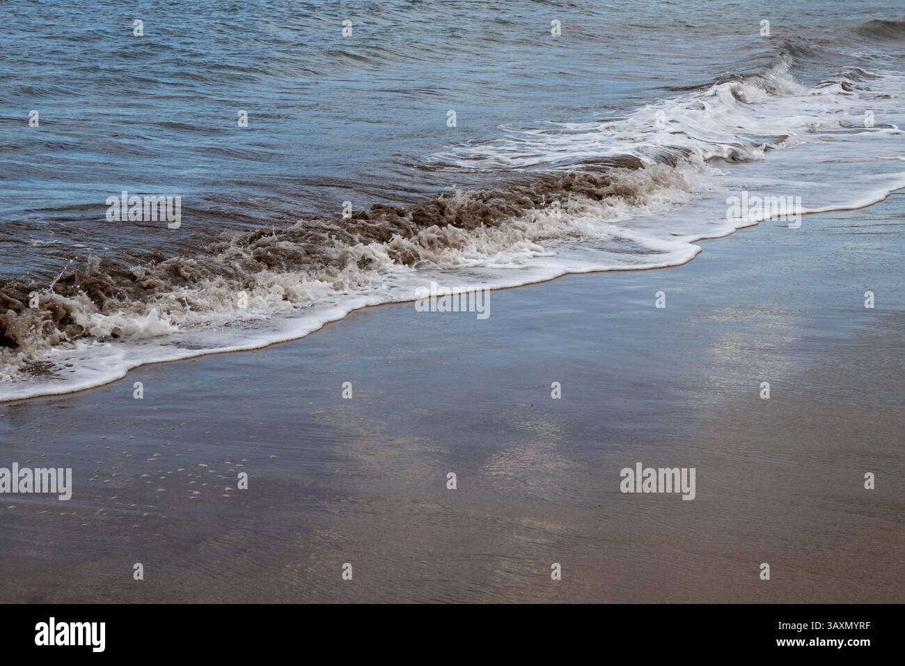 Plage de sable en début de soirée, lorsque le soleil est bas. Ligne de la marée et reflet du soleil, du ciel et des nuages. Playa del Cabron, Las Palmas, G. Banque D'Images