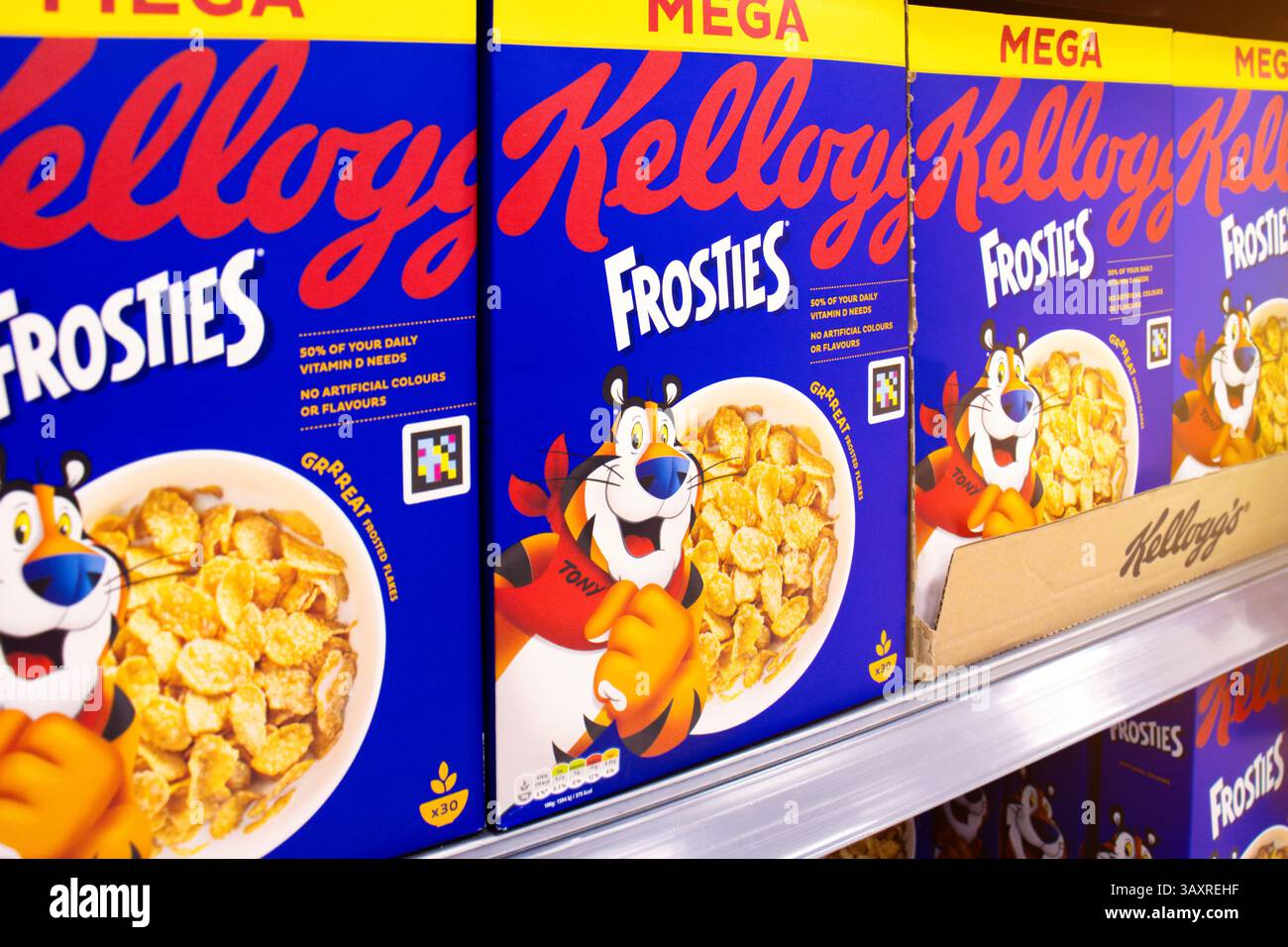 Boîtes de céréales Frosties Frosted Flakes de Kellogg's en stock sur l'étagère du magasin de détail. Les céréales pour petit déjeuner au maïs grillé emblématiques sont une marque mondiale classique. Banque D'Images