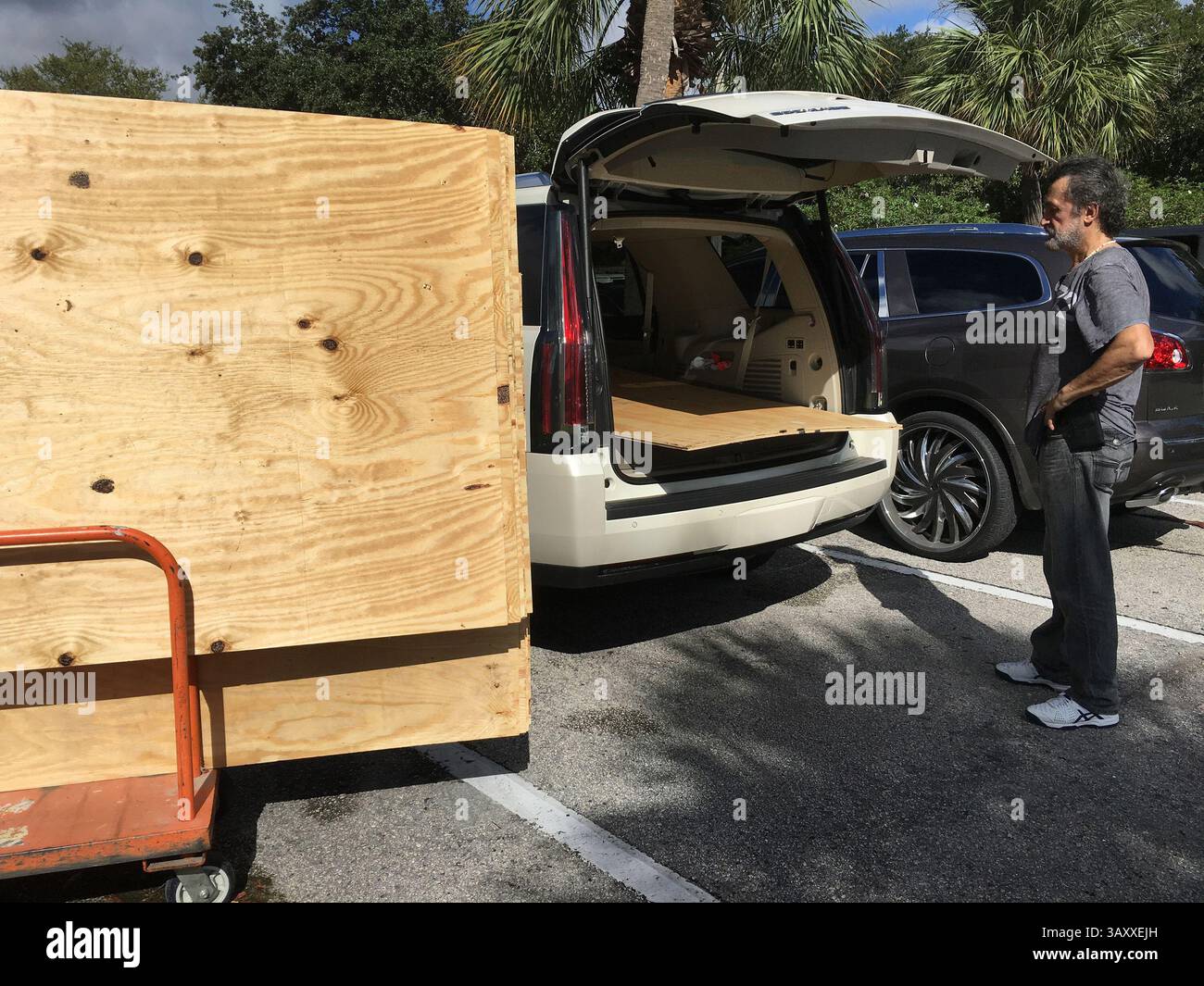 4 octobre 2016 - FL, USA - Danny Delarocca, de Boca Raton, Floride, charge du contreplaqué sur la voiture de son frère au Home Depot de Deerfield Beach le mardi 4 octobre 2016. Alors que l'ouragan Matthew menace de plus en plus le sud de la Floride, de plus en plus de gens se dirigent vers les magasins pour s'approvisionner en fournitures. (Crédit image : © Maria Lorenzino/TNS via ZUMA Wire) Banque D'Images