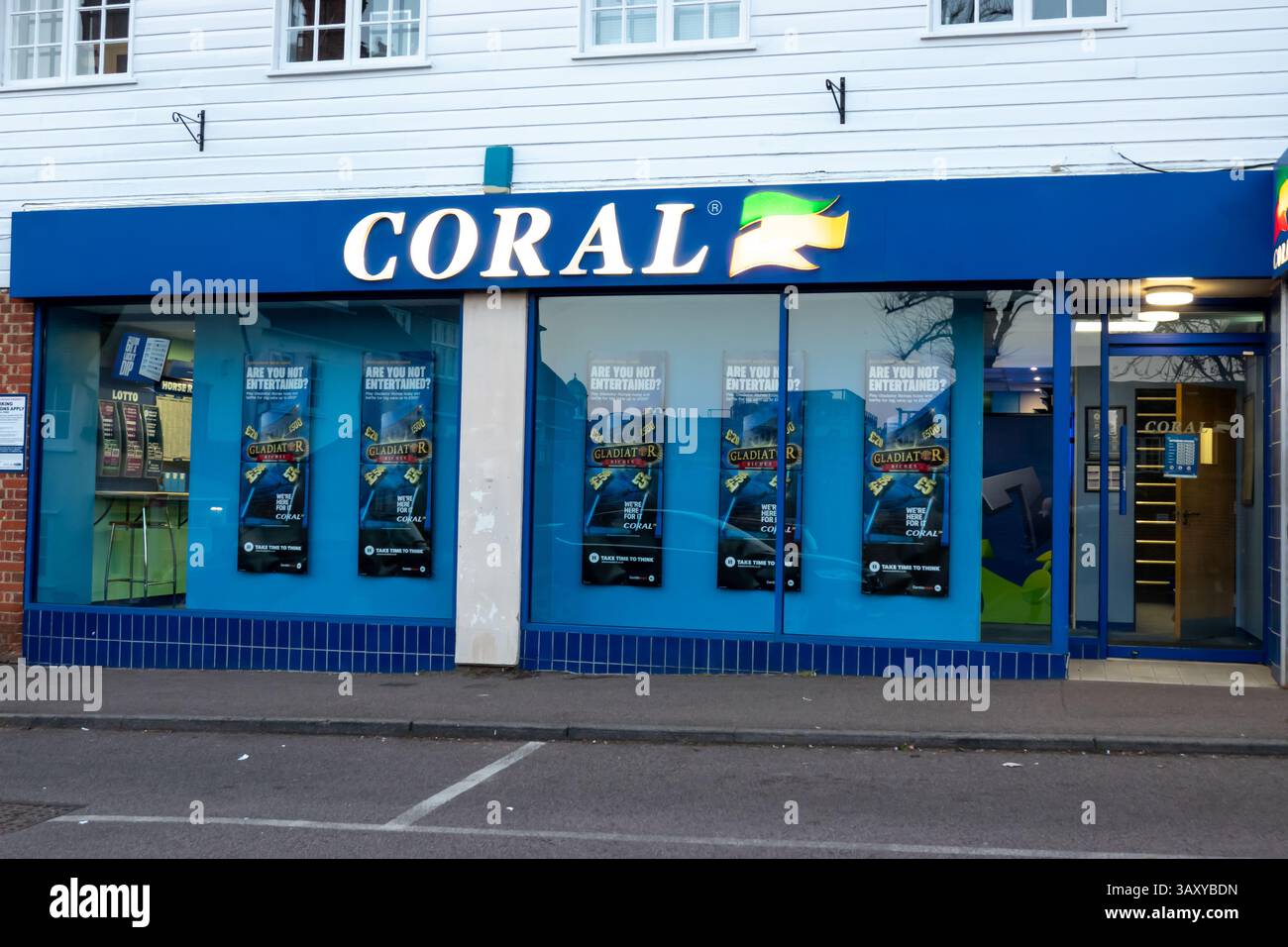 Une vue de rue d'un magasin de Paris Coral à Saffron Walden, Essex, mettant en vedette des enseignes et des affiches. C'est une photo de la vitrine. Banque D'Images
