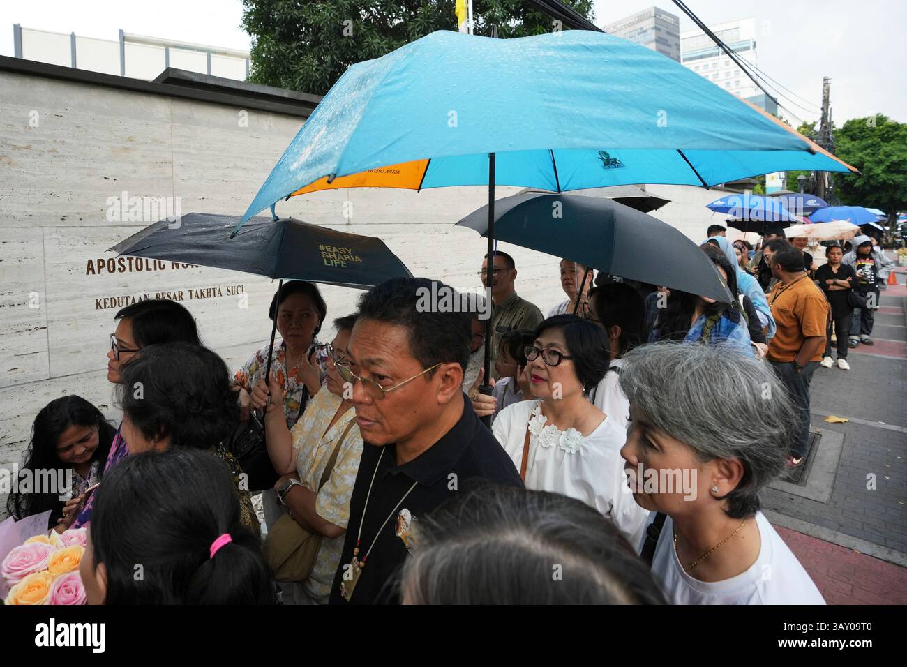 People wait in line to offer their condolences at the Apostolic Nunciature in Jakarta, Indonesia, Tuesday, April 22, 2025. (AP Photo/Achmad Ibrahim) Banque D'Images