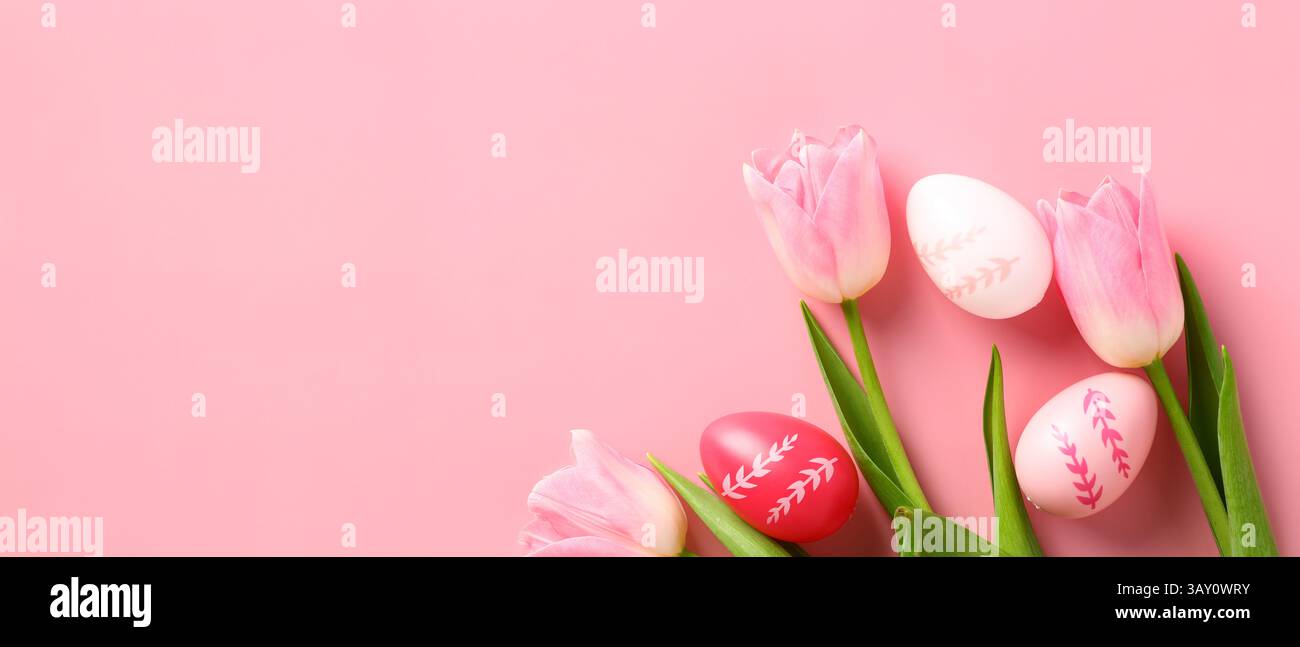 Conception de bannière joyeuse Pâques. Oeufs de Pâques colorés et tulipes sur fond rose. Banque D'Images