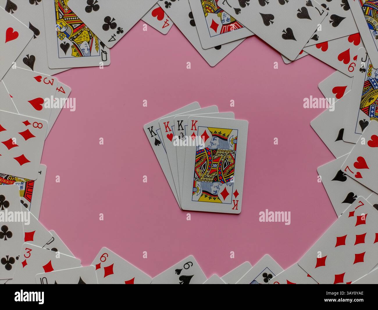 cartes à jouer, formant un rectangle sur un fond rose uni. Au centre du cœur, quatre cartes Roi sont empilées avec des cartes formant limite - Image de stock capturée avec un smartphone