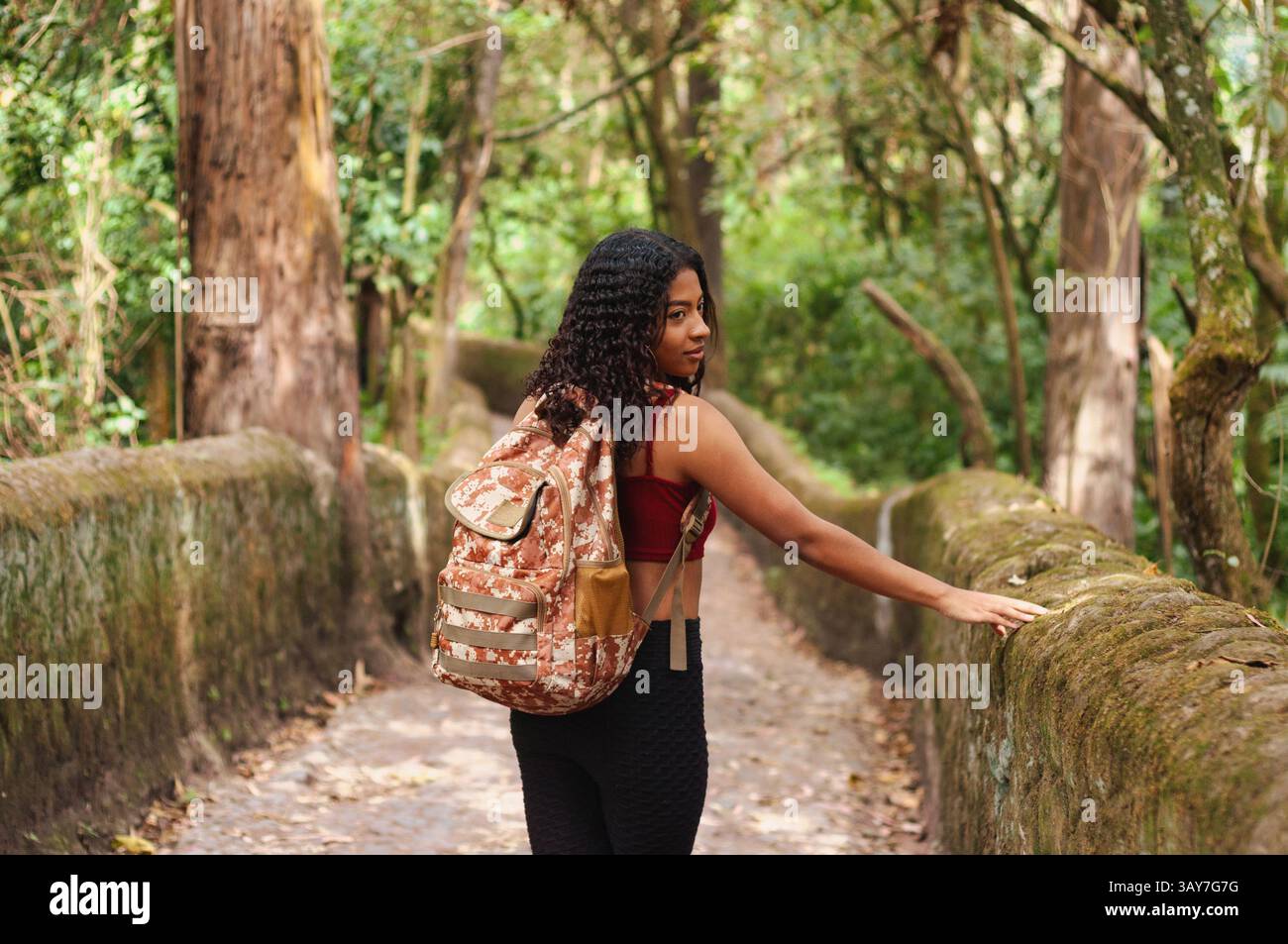 Une femme marche le long d'un sentier forestier pittoresque, profitant de la beauté de la nature tout en cherchant de nouvelles aventures Banque D'Images