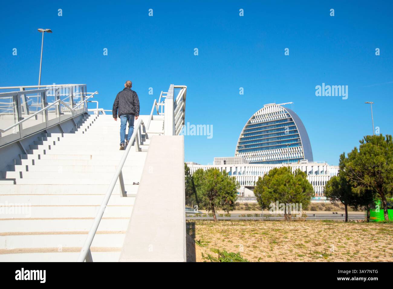 Homme marchant à l'étage pour la passerelle sur l'autoroute A-1 et la vue de la Vela bâtiment. Sanchinarro, Madrid, Espagne. Banque D'Images