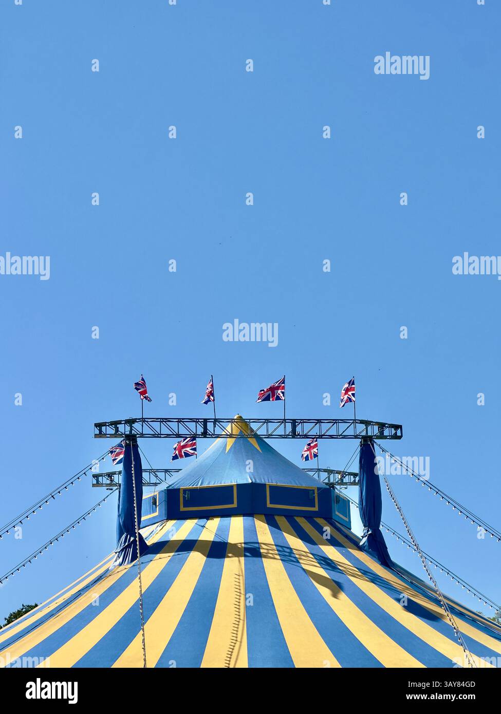 17 avril 2025 - Cambridge, Royaume-Uni - Une tente de cirque Big Top avec des drapeaux de l'Union Jack britannique volant un jour d'été. Banque D'Images