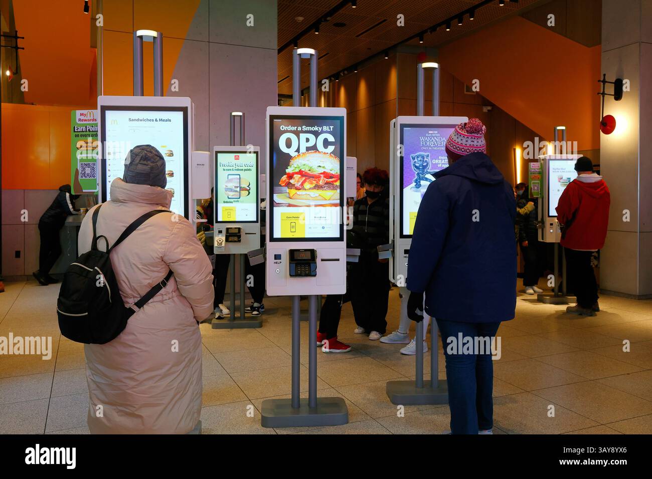 Les gens d'un McDonald's à New York utilisent un kiosque de commande numérique libre-service pour commander de la nourriture. les kiosques sont tactiles et sans espèces Banque D'Images