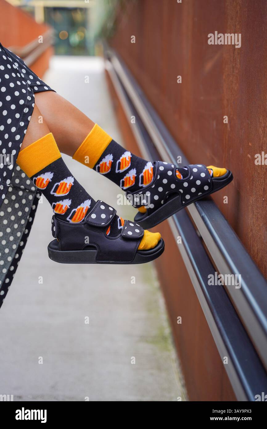 Style Street ludique : Sandales noires et chaussettes colorées sur les marches de la ville Banque D'Images