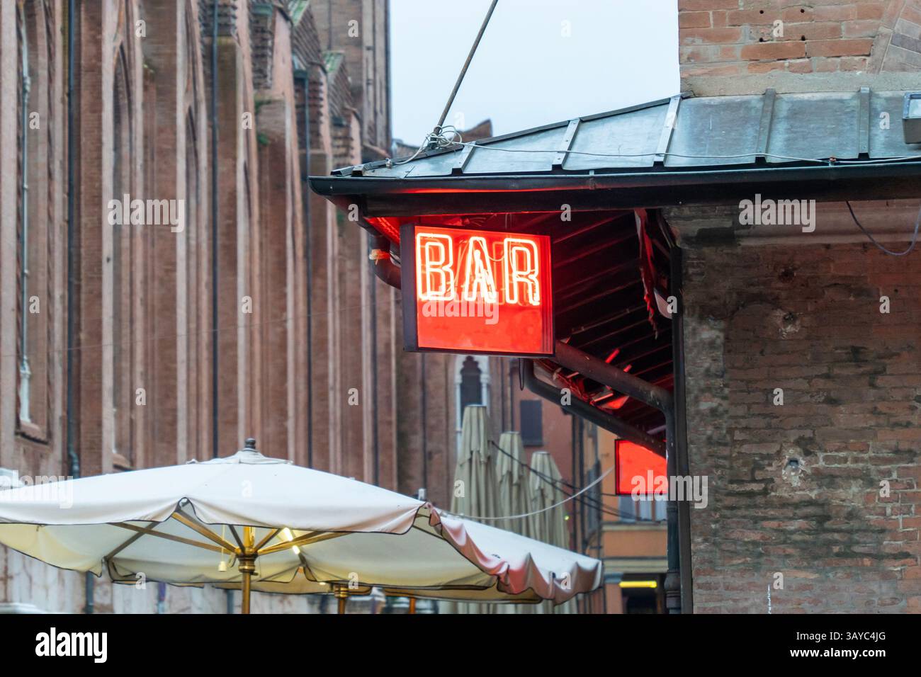 Rouge néon Bar signe sur une rue dans le quartier historique de Bologne Banque D'Images