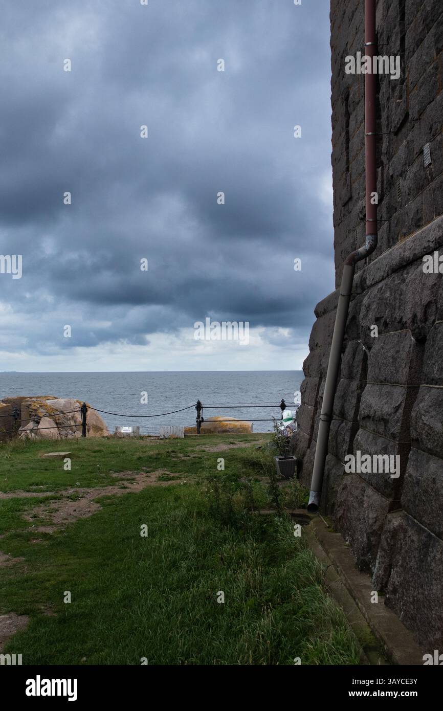 Une grande structure en pierre encadrant une vue sur la mer par temps couvert. Banque D'Images