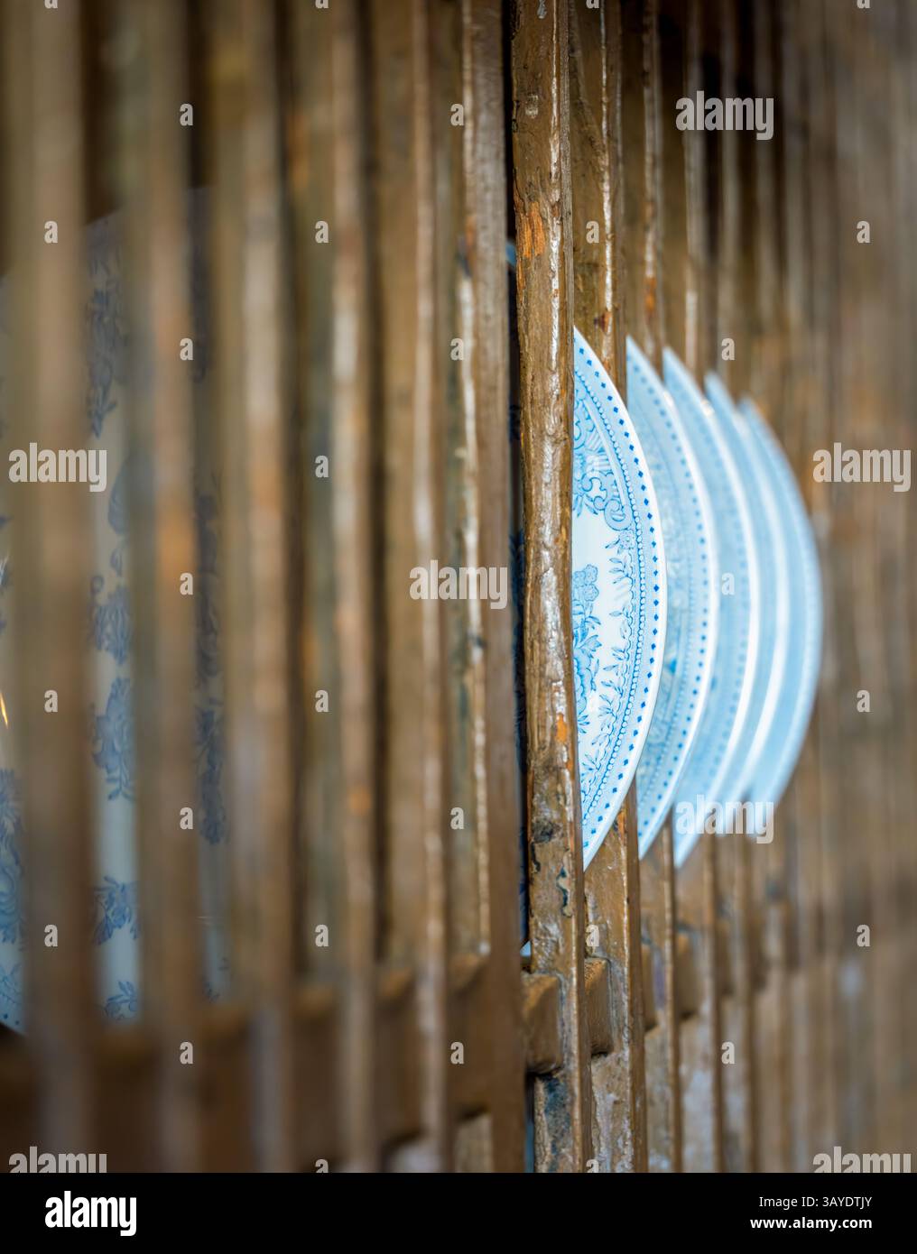 Alignement en gros plan de plaques de transfert bleues et blanches imbriquées dans un rack en bois vieilli mettant en évidence le contraste de texture et la géométrie rythmique Banque D'Images