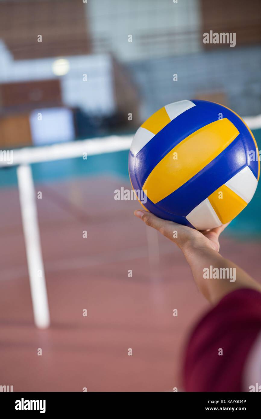Athlète tenant du volley sur un terrain de volley-ball intérieur, avec filet et lignes de volley-ball, espace de copie Banque D'Images