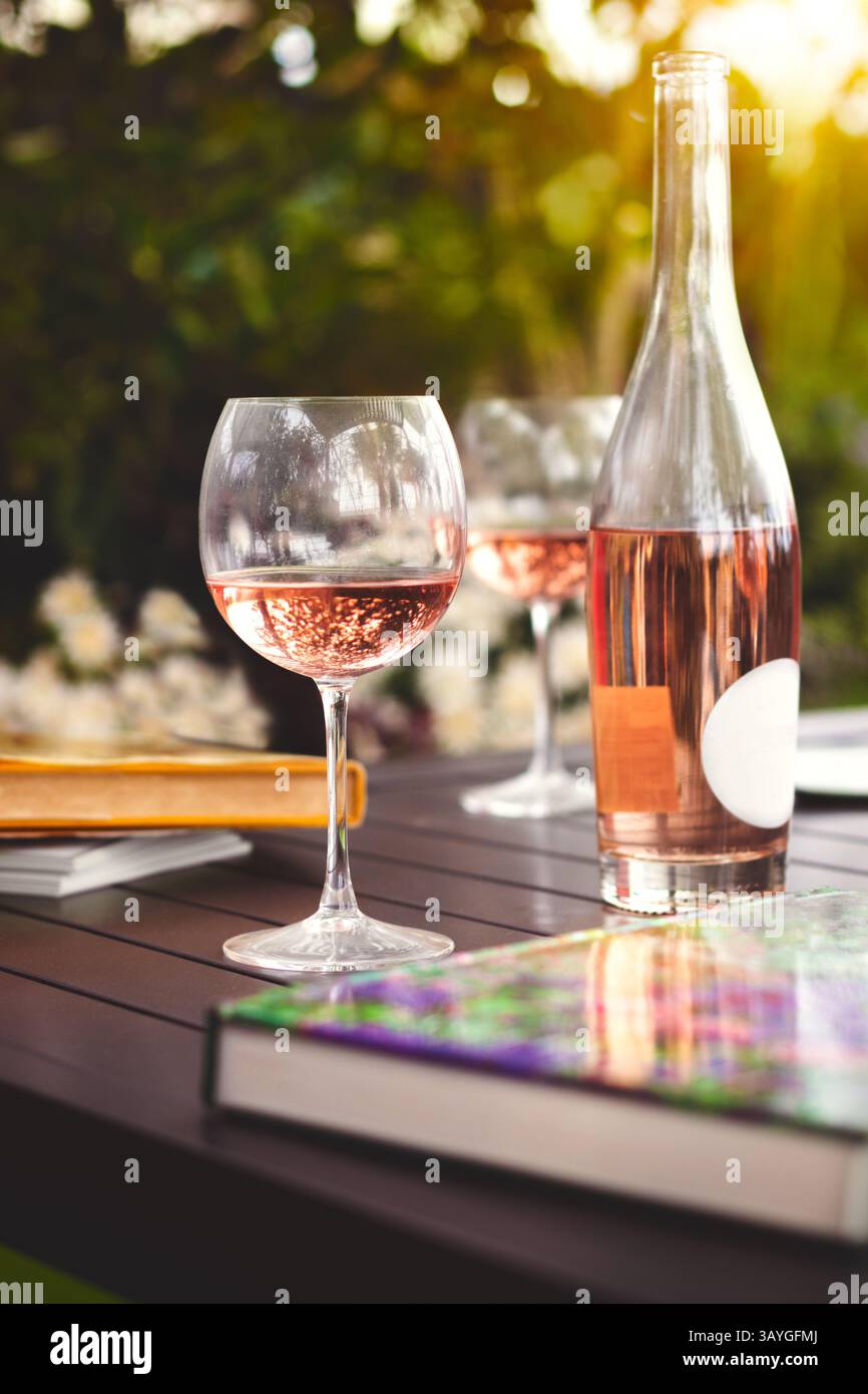 Dîner en plein air en été. Fête en plein air décorée avec des fleurs fraîches et des livres de lecture. Banque D'Images