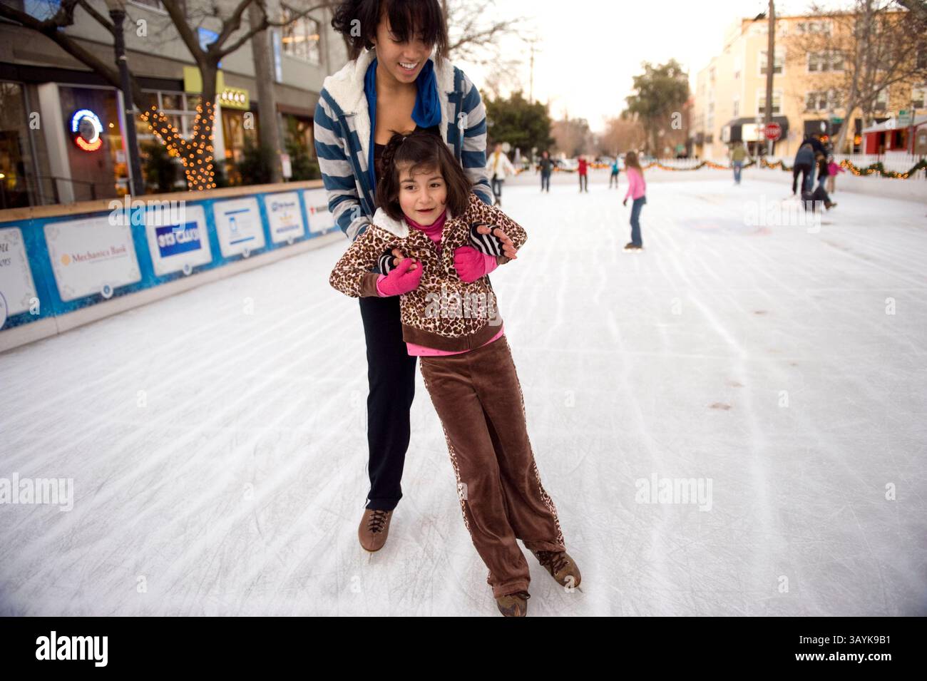 04 janvier 2010 - Sacramento, USA - la garde de skate Jessica Williams donne à Mariann (cq - no ''e'') Mendez, 6 ans, une leçon impromptue lundi, 4 janvier 2010 la patinoire de Midtown. La patinoire a déménagé à l’emplacement de la 20e Rue cette année après que la construction de la route a fermé l’ancien spot du centre-ville, le plaçant maintenant au cœur des activités mensuelles du deuxième samedi. Ce samedi, les organisateurs présenteront un spectacle de patinage artistique chorégraphié pendant la populaire promenade artistique en plein air. La patinoire peut accueillir plus de 200 patineurs à tout moment et a attiré une vingtaine de milliers de personnes depuis son ouverture vers la fin de Nove Banque D'Images