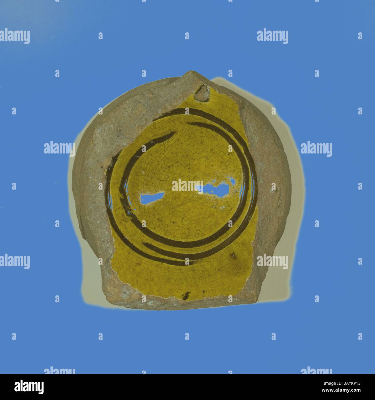 Fragment de poterie orné d'un émail jaune éclatant, orné d'un motif circulaire délimité par des lignes sombres, placé sur un fond contrasté. La pièce montre des signes de l'âge et de l'artisanat, reflétant sa signification historique. Fragment de bol, 13ème/14ème siècle, Byzantine, Grèce, Thessalonique, Istanbul, céramique, 2,2 × 7 × 6 cm (7/8 × 2 3/4 × 2 3/8 po) Art classique avec une touche moderne réinventé par Artotop Banque D'Images